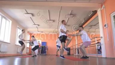 在一个现代化的健身中心里和白种人一起上课，在健身房里集体运动以增强肌肉和输球